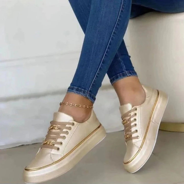 Damsneakers med gulddetaljer